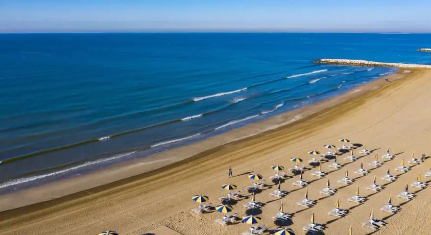 Spiaggia di Cavallino-Treporti con ombrelloni e lettini pronti per l'estate. Scopri come arrivare in questo paradiso!
