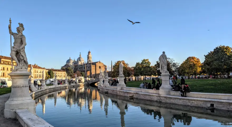 Statue e canale a Padova, con la Basilica di Sant'Antonio sullo sfondo. Ideale per capire quanti giorni per visitare Padova.