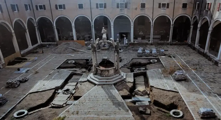 Cortile di Venezia con pozzi in fase di scavo. Archeologia in corso, tra terra e antiche pietre.