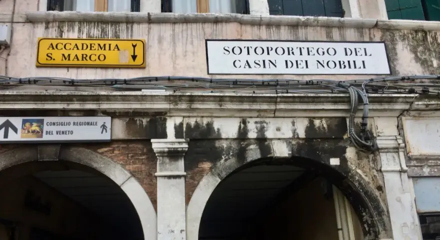 Segnali stradali a Venezia indicano "Accademia S. Marco" e "Sotoportego del Casin dei Nobili".