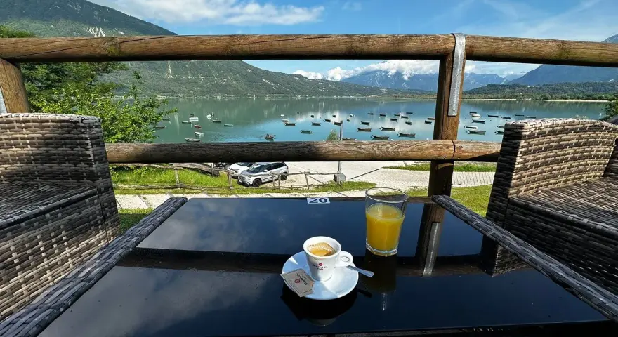 Un caffè e un succo d'arancia con vista sul lago di Santa Croce, ideale per un momento di relax e per decidere dove mangiare.