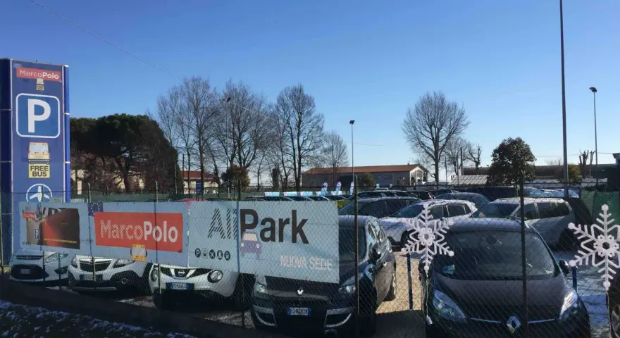 Parcheggio all'aeroporto di Venezia Marco Polo con cartelli informativi e auto in sosta.