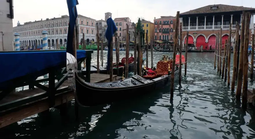 Gondole ormeggiate in un canale veneziano, con palazzi storici sullo sfondo. Immagine che evoca il fascino di quando è stata costruita Venezia.