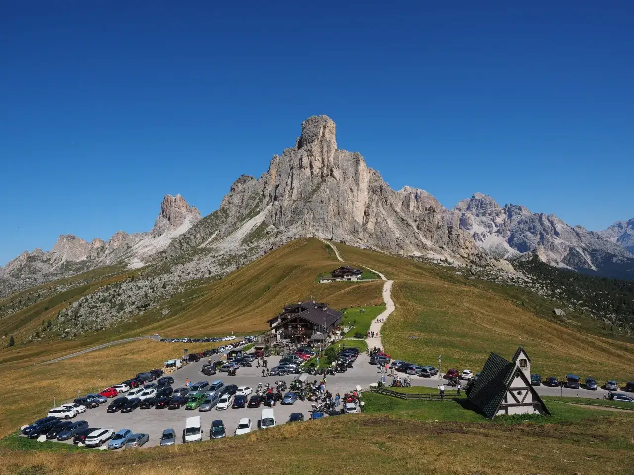 Rifugi Dolomiti Bellunesi facili da raggiungere in auto, con parcheggio pieno e sentieri che portano verso le vette maestose.