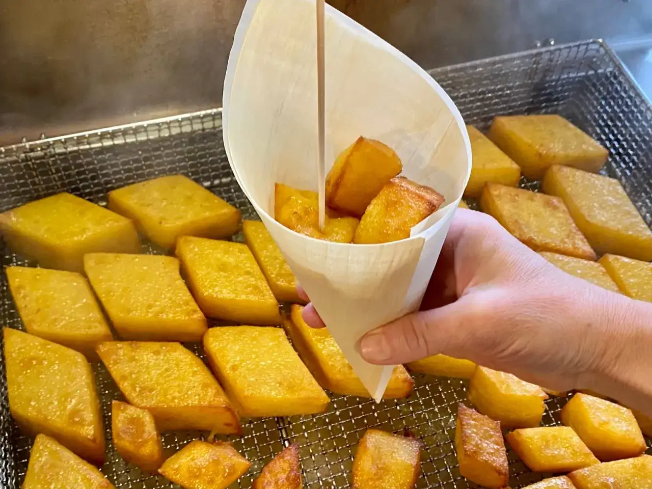 Dorata crema fritta chioggiotta, croccante fuori e morbida dentro, servita in un cono di carta.