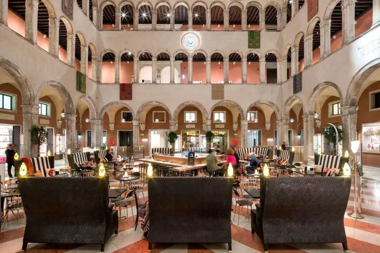 Atrio di lusso a Venezia, con arcate, negozi e un'area lounge. Perfetto per una via dello shopping veneziana.