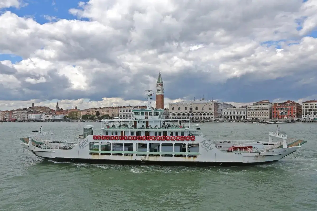 Traghetto ACTV che naviga sul Canal Grande a Venezia, con il Palazzo Ducale e il Campanile di San Marco sullo sfondo.