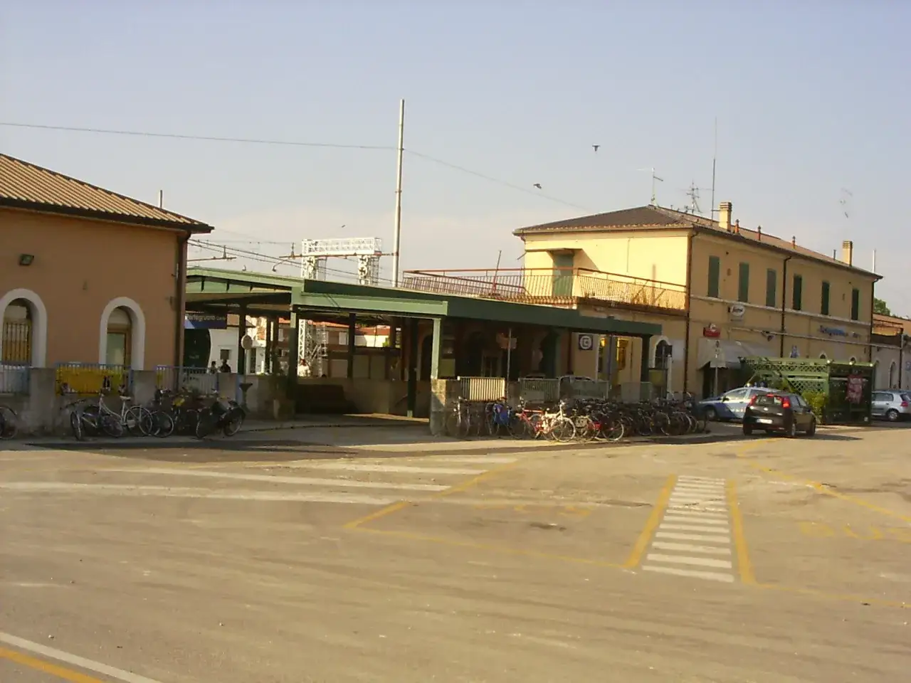 Stazione di Portogruaro Caorle con biciclette parcheggiate e un'auto nera.