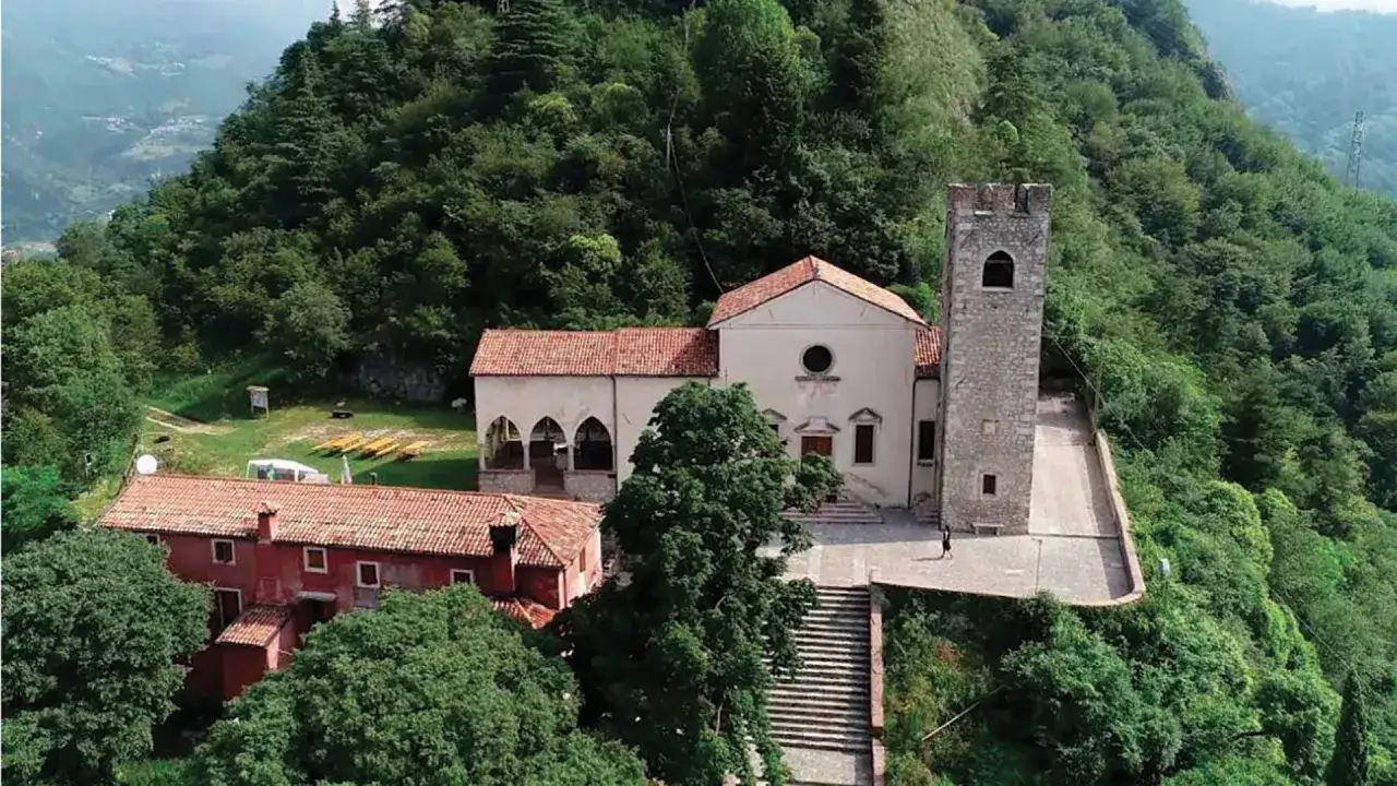 Un borgo storico con una torre e una chiesa, immerso nel verde. Un luogo incantevole da scoprire, tra le cose da vedere a Vittorio Veneto.