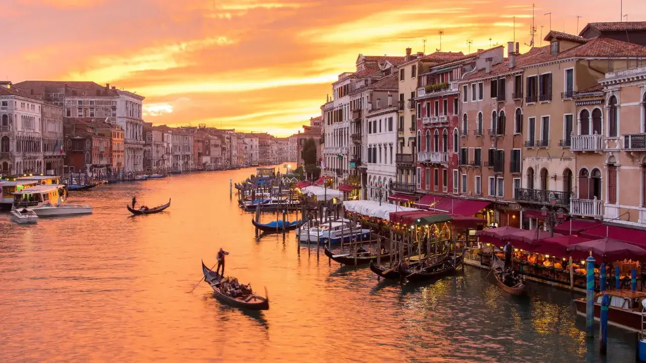 Tramonto sul Canal Grande, perfetto per un itinerario Venezia a piedi. Gondole e palazzi storici creano un'atmosfera magica.