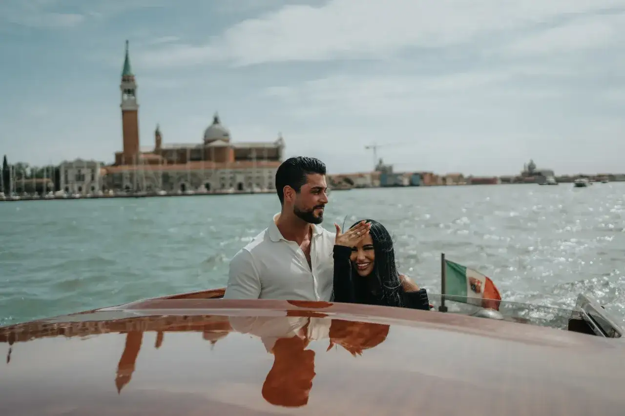 Coppia felice in barca a Venezia, con un anello scintillante e lo skyline sullo sfondo. Un momento perfetto per una proposta matrimonio Venezia.