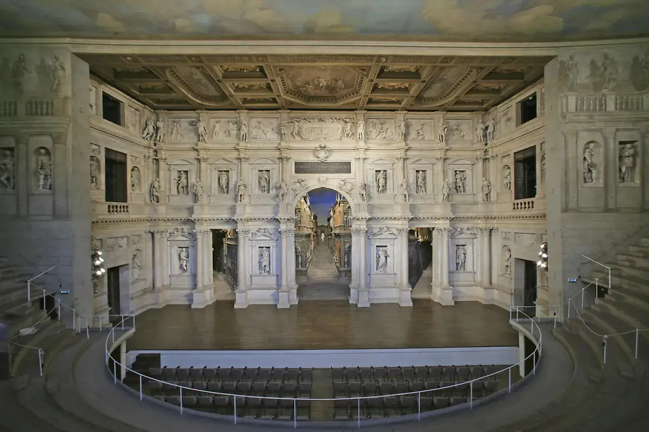 Interno del Teatro Olimpico, gioiello di una città veneta, con la sua scenografia prospettica e le statue che adornano le pareti.