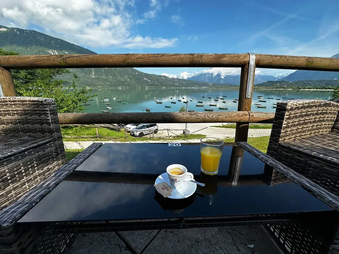 Tavolino con caffè e succo d'arancia, vista sul lago di Santa Croce dove mangiare.