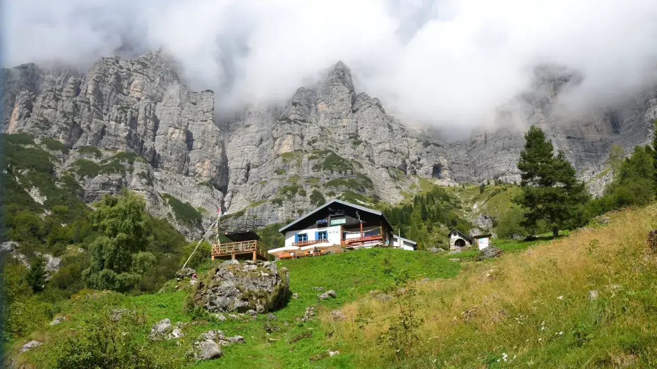 Rifugio alpino accogliente tra le imponenti vette delle Dolomiti Bellunesi, un luogo ideale per escursioni facili e rilassanti.