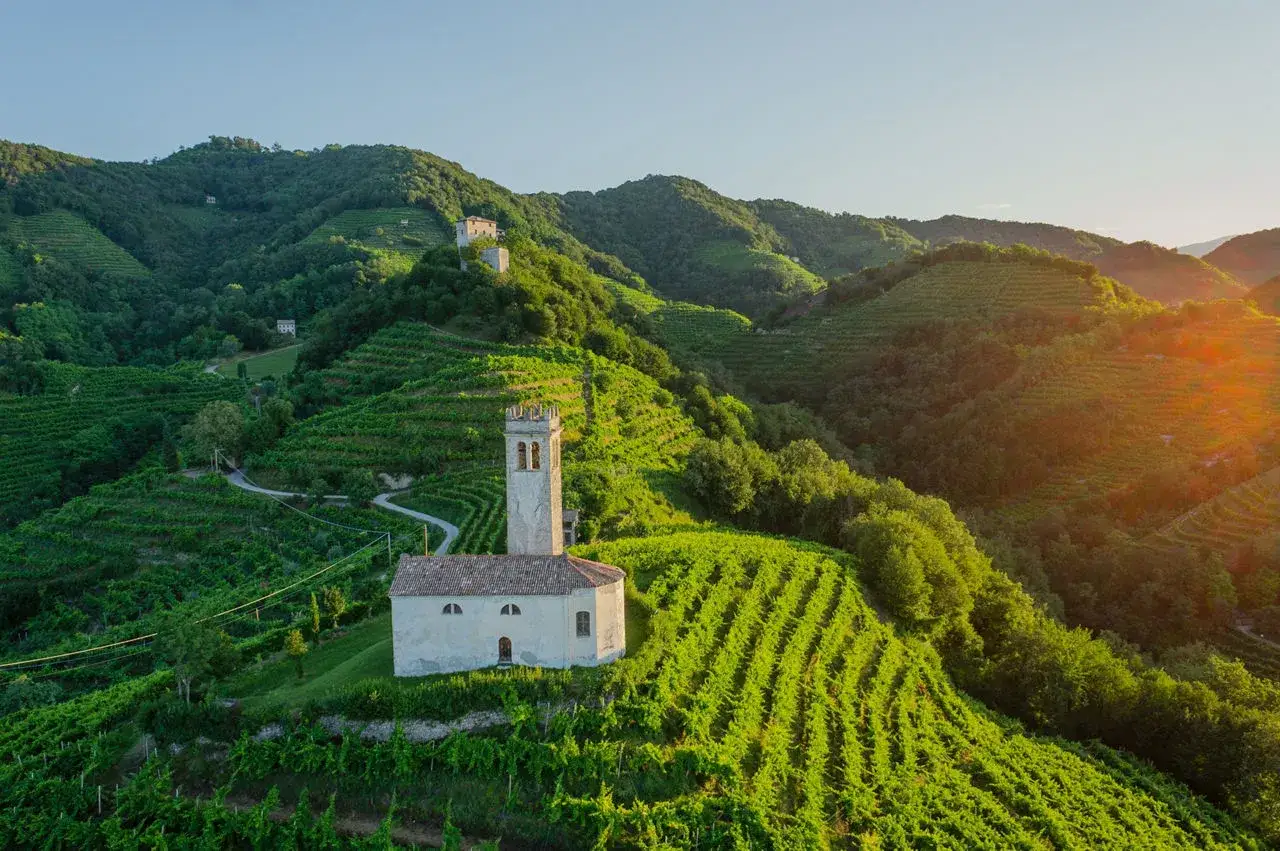 Un borgo con una chiesetta e campanile tra colline vitate, un gioiello da scoprire tra le cose da vedere nei dintorni di Treviso.