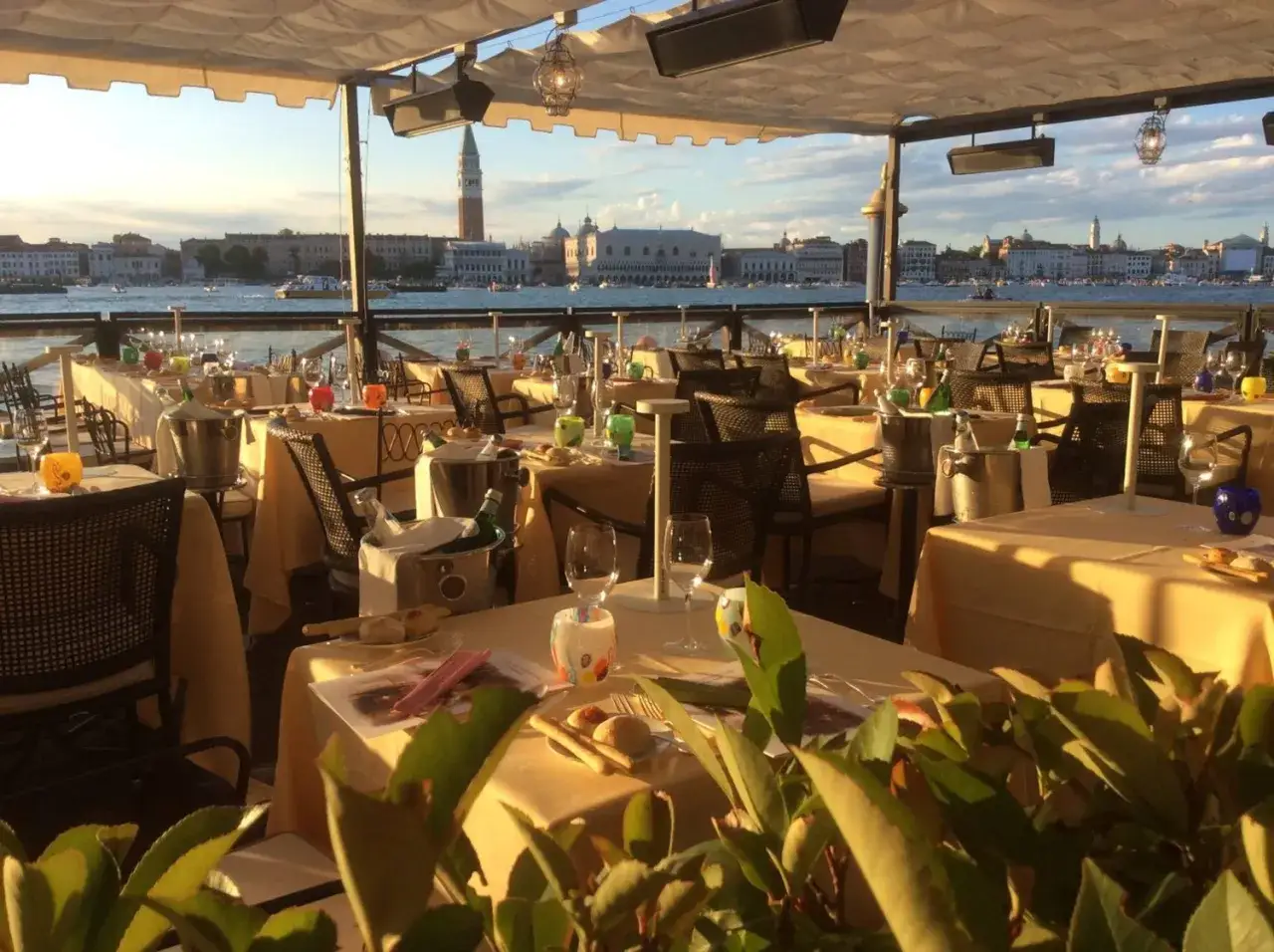 Tavoli apparecchiati con vista su Venezia, un'ambientazione perfetta per scoprire i migliori ristoranti a Venezia.