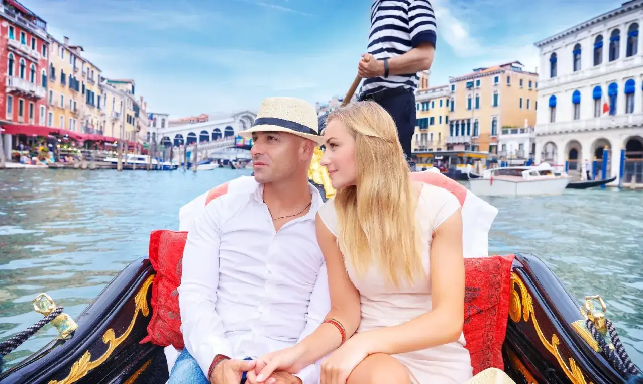 Coppia romantica in gondola sul Canal Grande, un'esperienza da non perdere per scoprire quanto costa un giro in gondola a Venezia.