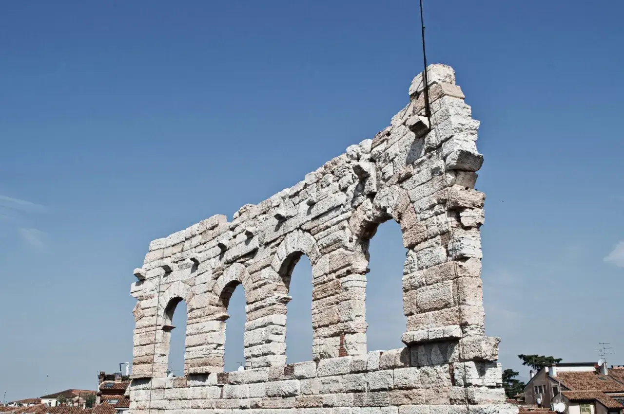 L'arena di Verona, simile al Colosseo, mostra le sue antiche arcate contro un cielo azzurro.